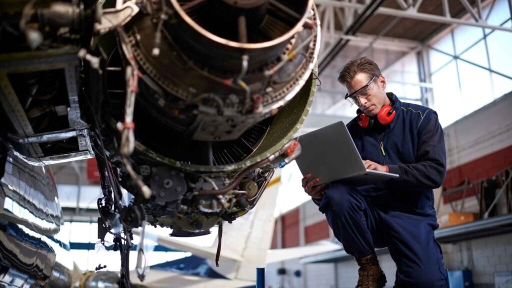 Mecânico fazendo manutenção em motor de avião.