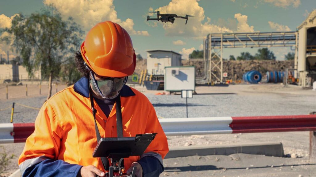 Operário pilotando drone em obra.